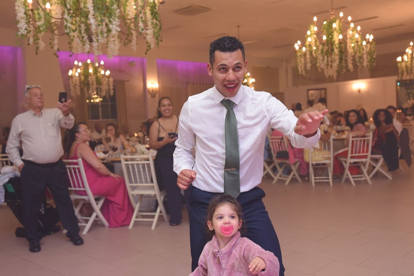 Pai a dançar com a filha pequena na pista, num casamento real