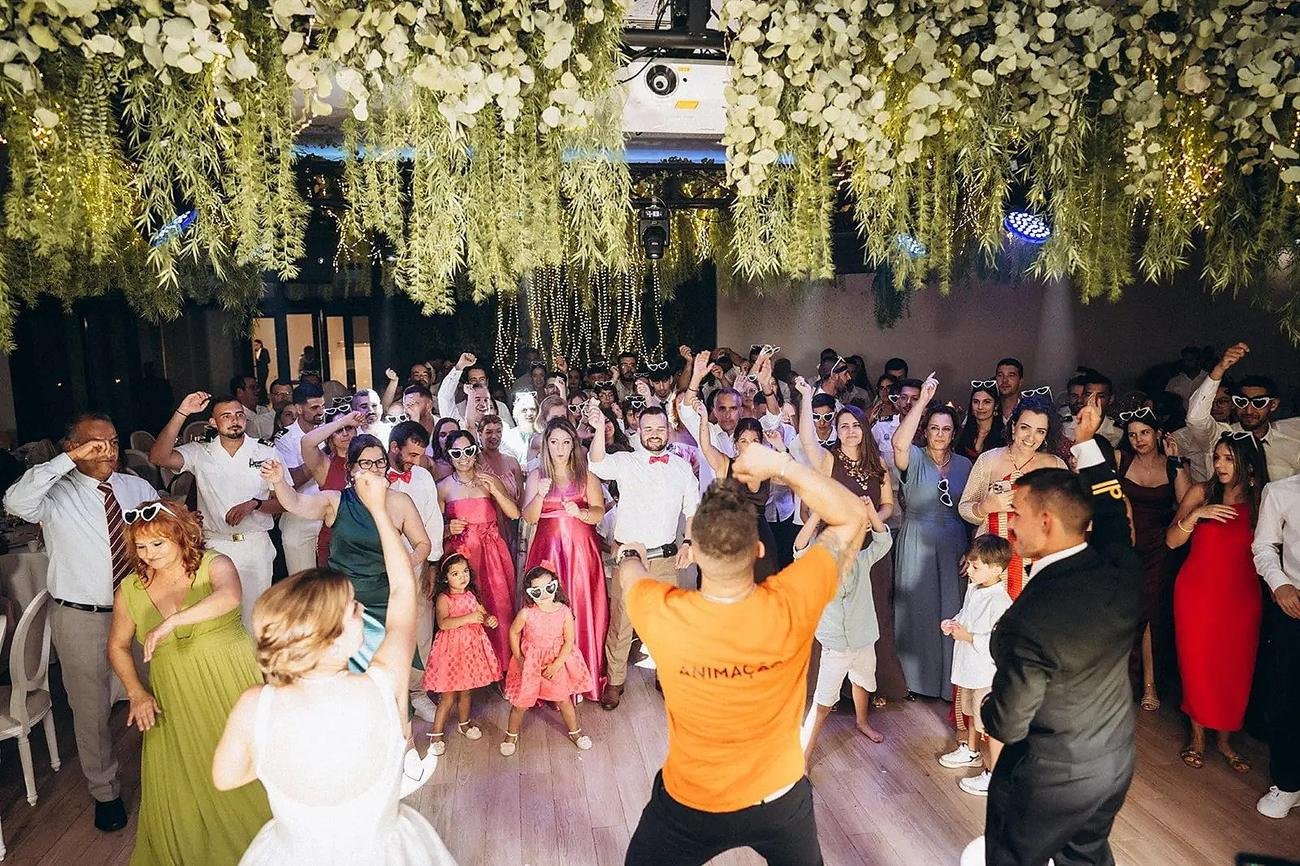 Pista completamente cheia, convidados de mãos ao alto com a Team Brasa