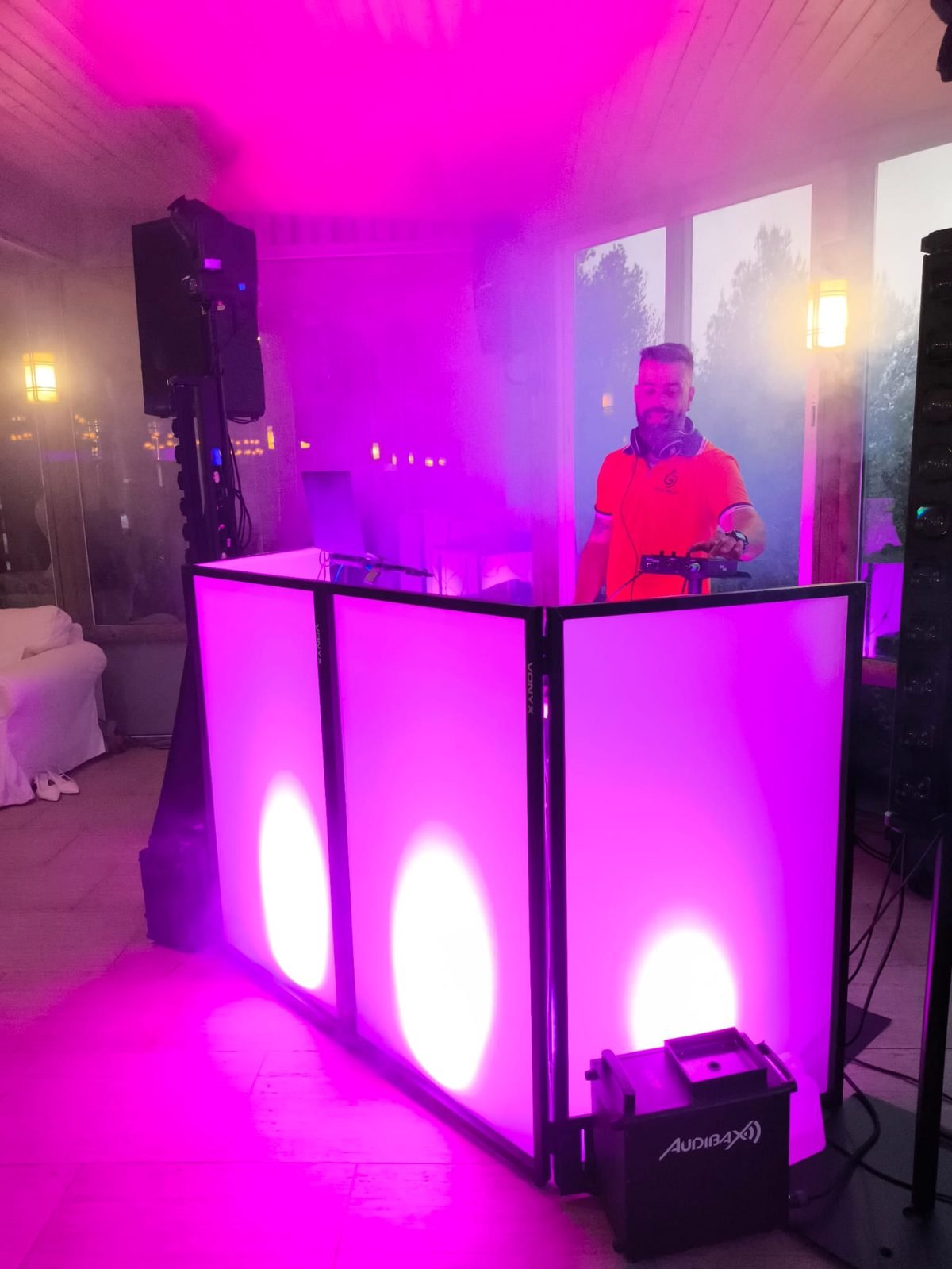 Cabine de DJ iluminada em magenta com fumo baixo