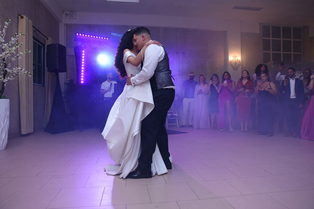 Primeira dança dos noivos, pista cheia de convidados à volta, num casamento real