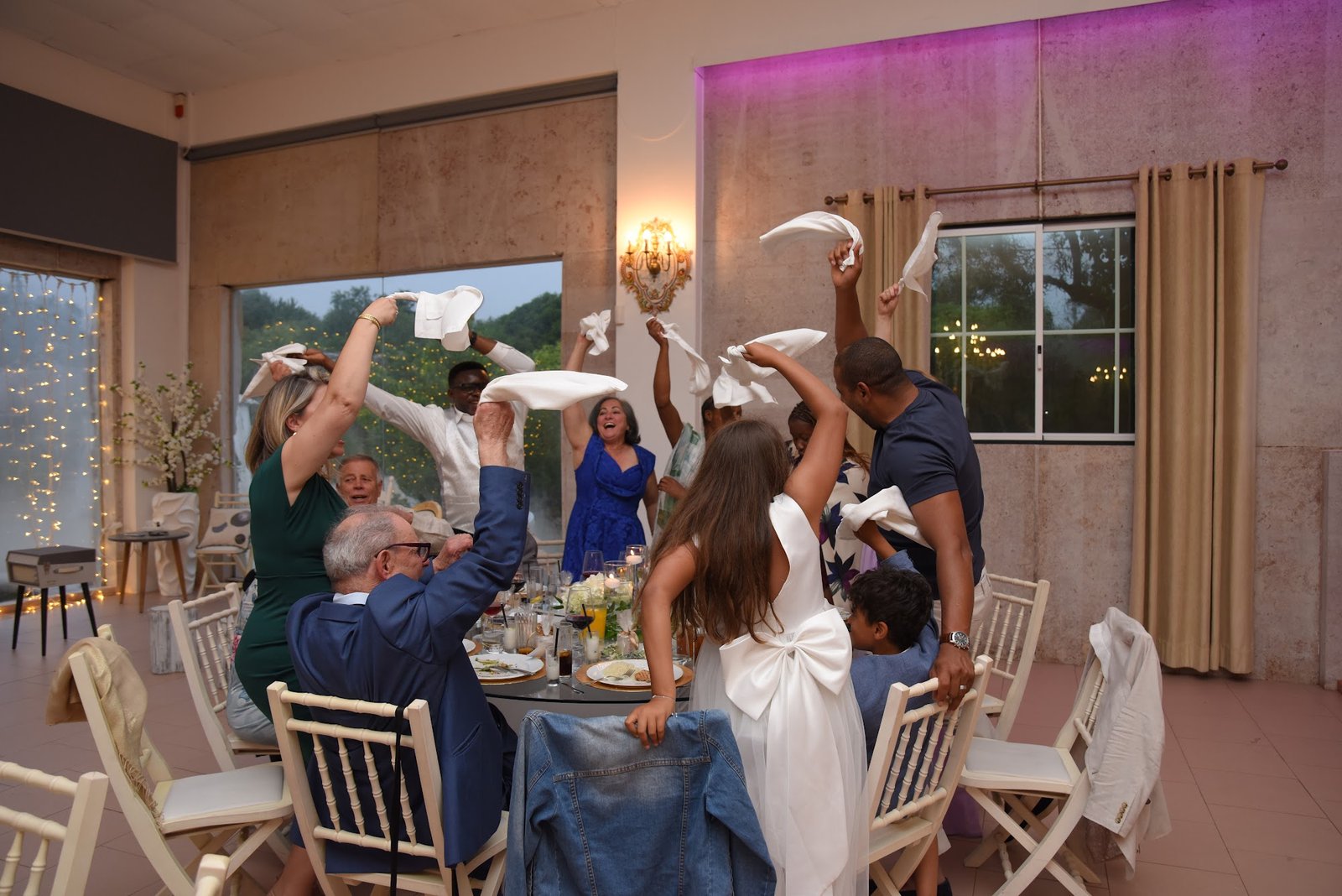 Convidados a acenar guardanapos brancos ao ar num casamento com família brasileira